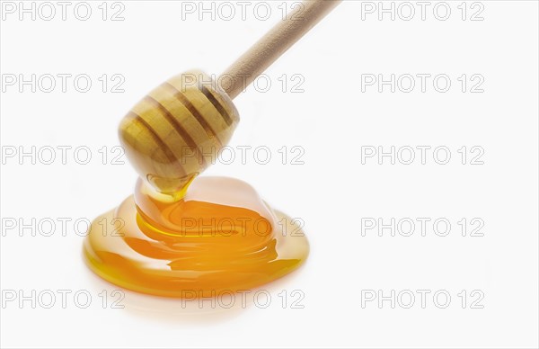 Honey dripping from honey dipper