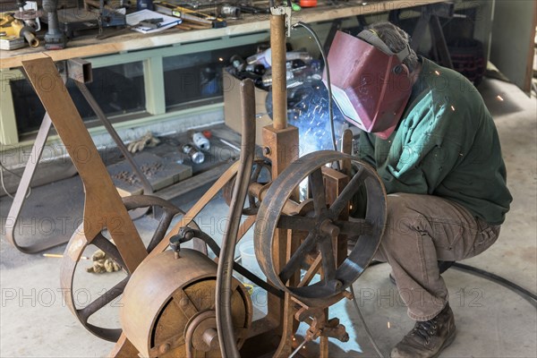 Artist welding steel in workshop