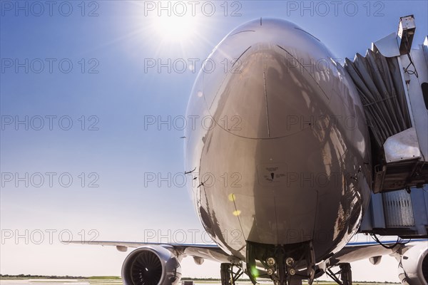 Low angle view of airplane at airport under blue sky