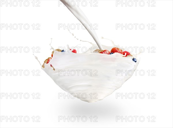 Floating milk splashing on cereal with fruit