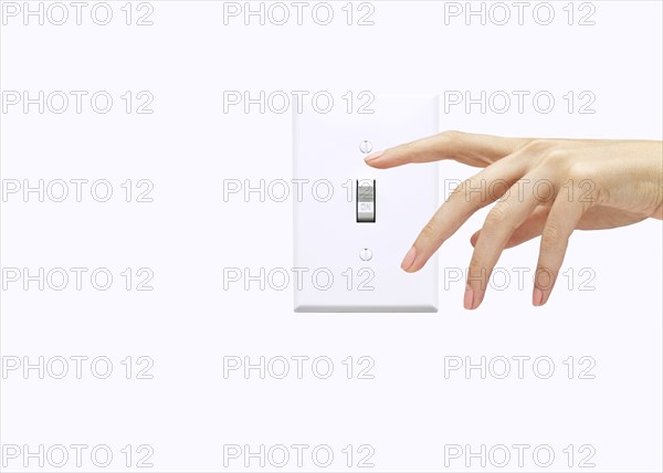 Hand of woman pressing light switch