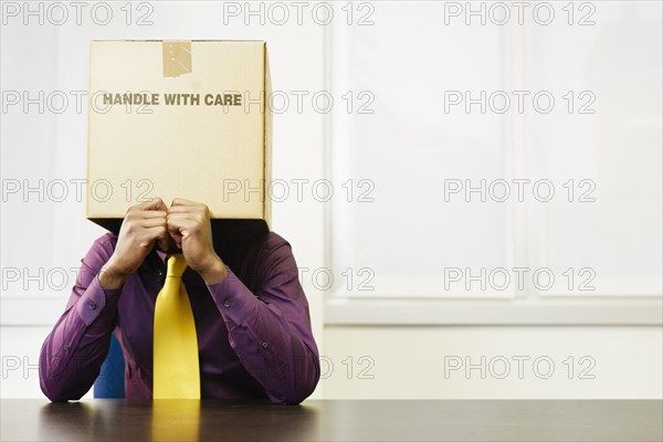 Black businessman with box over his head