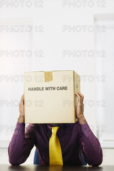 Black businessman with box over his head