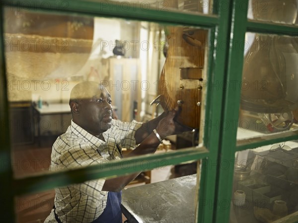 Black lute maker in workshop