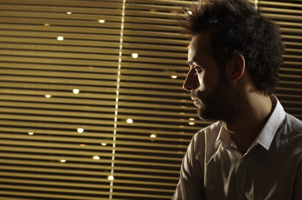 Caucasian man looking out window at night