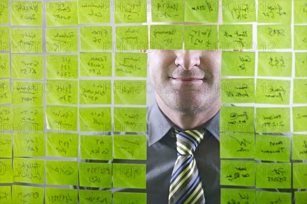 Caucasian businessman looking at adhesive notes on wall
