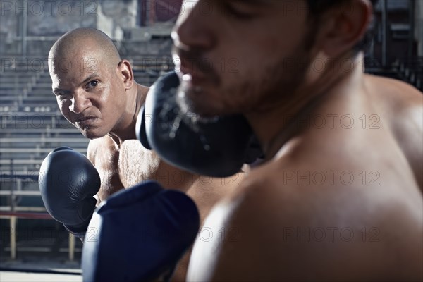 Hispanic boxers sparring in gym