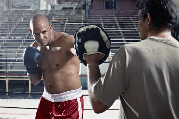 Hispanic boxers sparring in gym