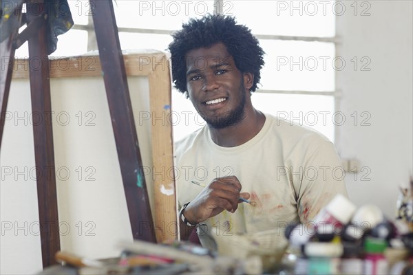 Black artist painting in art studio