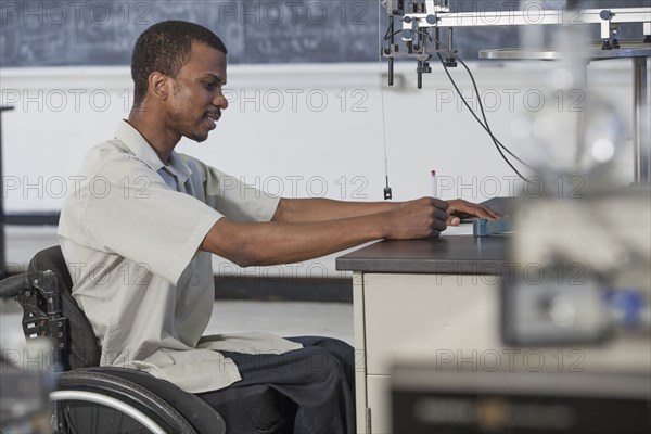 African American paraplegic student working in science classroom