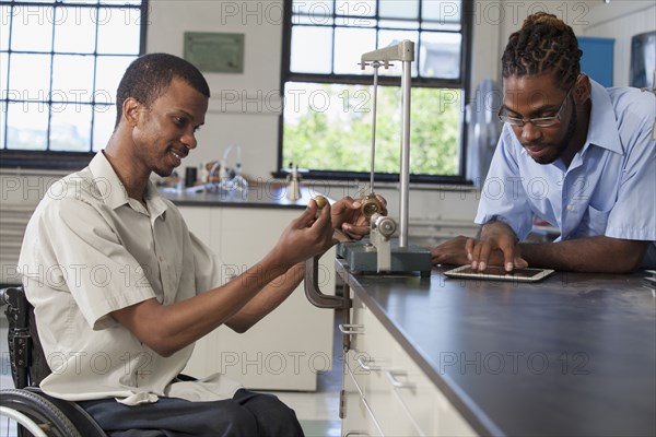 Paraplegic student and classmate working in science classroom