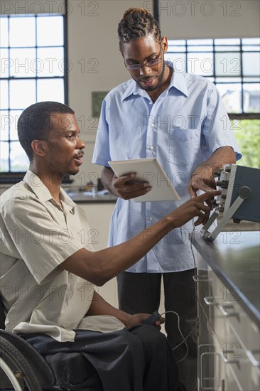 Paraplegic student and classmate working in science classroom