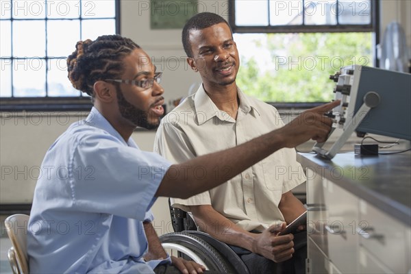 Paraplegic student and classmate working in science classroom