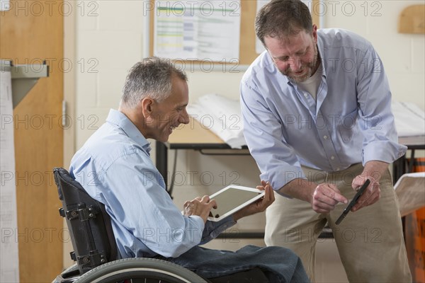 Caucasian architects using digital tablets in office