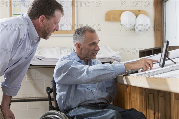 Caucasian architects using digital tablet in office