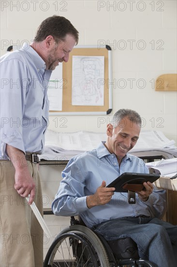 Caucasian architects using digital tablet in office