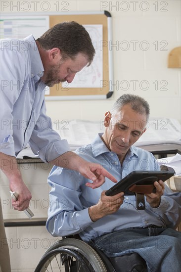 Caucasian architects using digital tablet in office