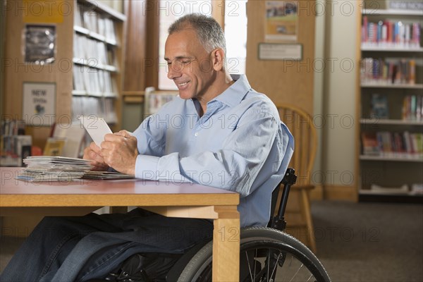 Caucasian man examining dvds in library