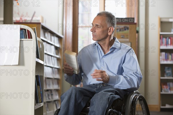 Caucasian man holding book in library