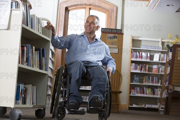 Caucasian man choosing book in library