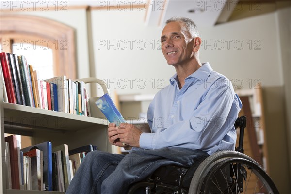 Caucasian man holding book in library