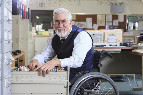 Caucasian businessman filing papers in office