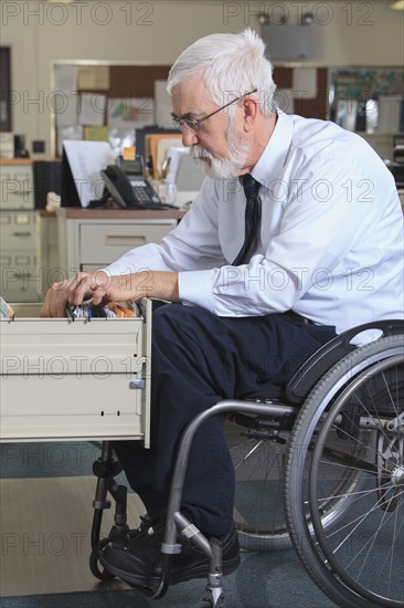 Caucasian businessman filing papers in office