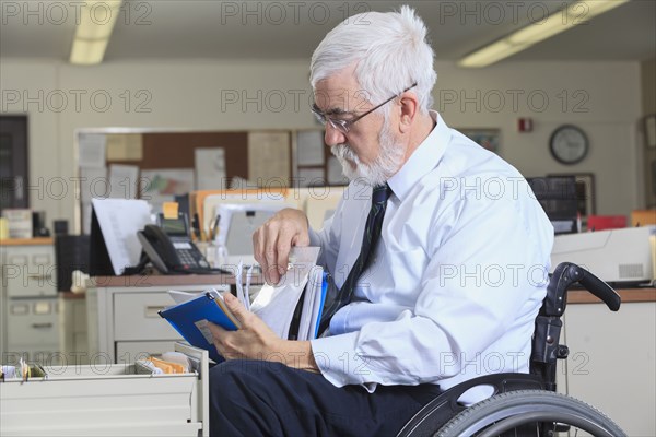 Caucasian businessman filing papers in office