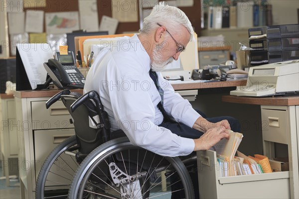 Caucasian businessman filing papers in office