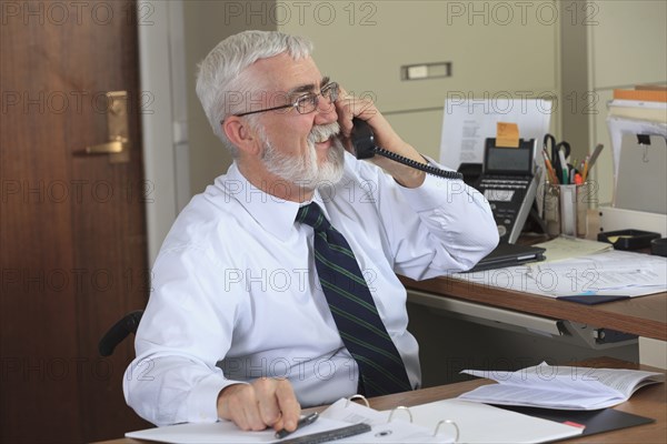 Caucasian businessman talking on phone in office