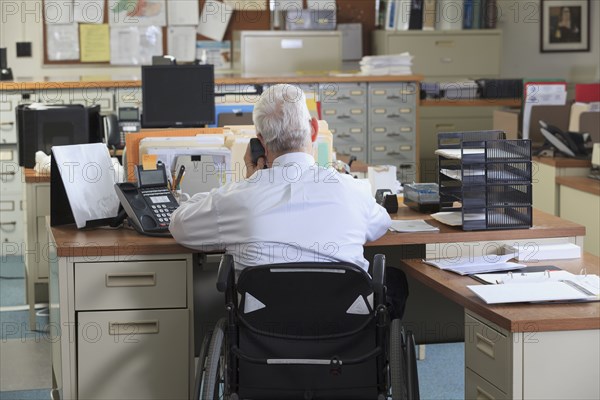 Caucasian businessman talking on phone in office