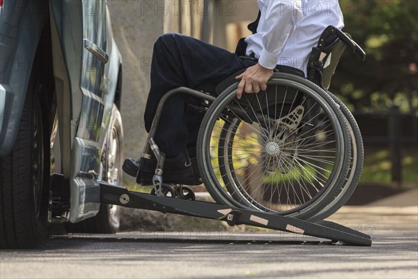 Caucasian businessman in wheelchair entering van