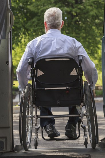 Caucasian businessman in wheelchair exiting van
