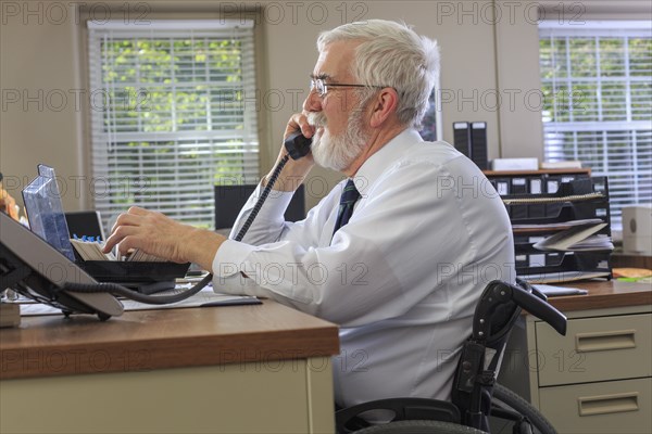 Caucasian businessman talking on phone at desk