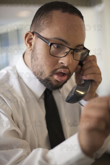 Mixed race man talking on telephone