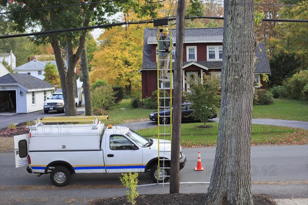 Caucasian worker installing cable on pole