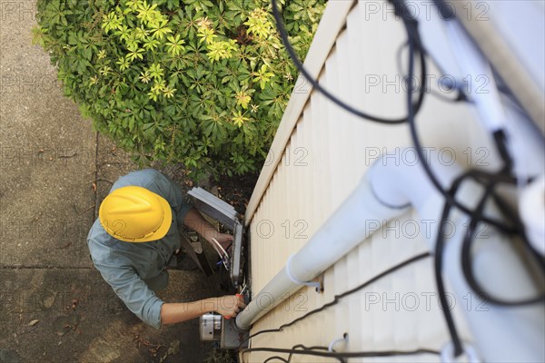 Caucasian worker installing cable box