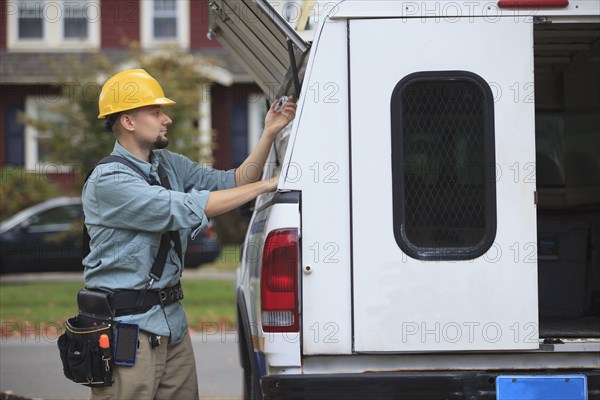 Caucasian worker pulling equipment from truck