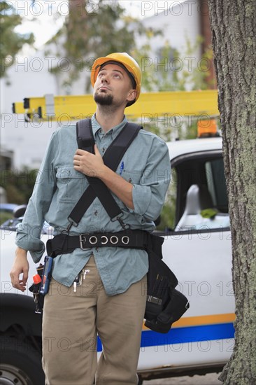 Caucasian worker walking under tree