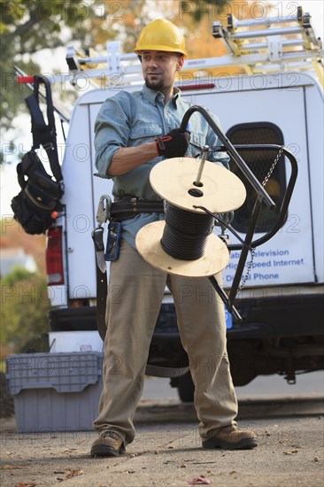 Caucasian worker holding cable spool