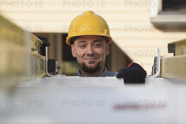 Caucasian installer pulling ladder from truck roof