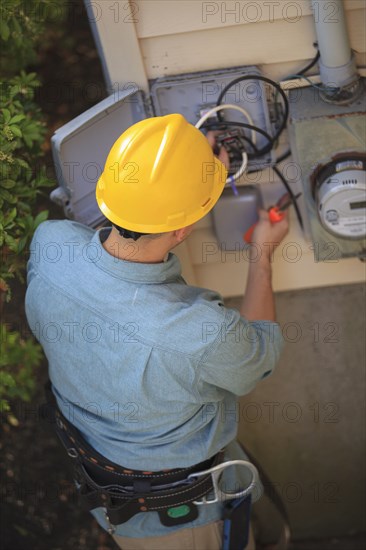 Caucasian worker installing cable box