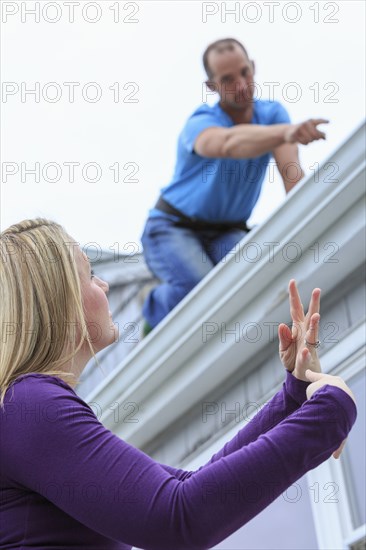 Caucasian homeowner signing to deaf roofer