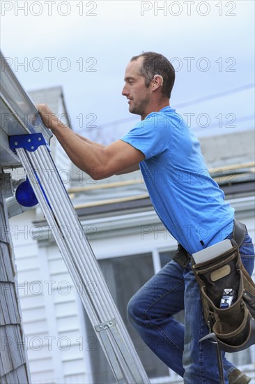 Deaf Caucasian roofer climbing ladder