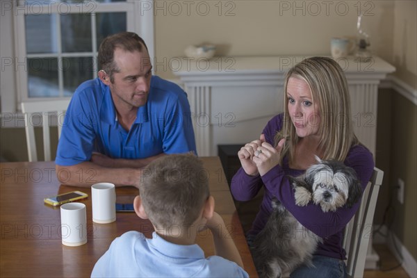 Caucasian family signing at dinner table