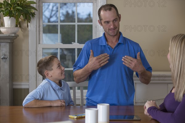 Caucasian family signing at dinner table