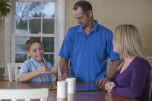 Caucasian family signing at dinner table