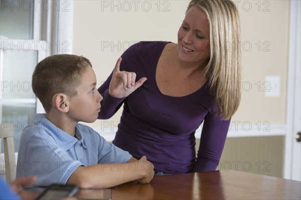 Caucasian mother signing with deaf son