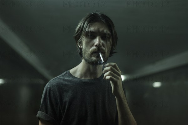 Caucasian man with beard smoking cigarette