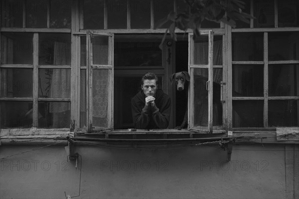 Caucasian man leaning in window with dog